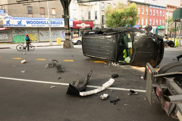 A man on a bicycle who was reportedly breaking into cars was rushed to hospital in critical condition after a man driving a Jeep Grand Cherokee SUV chased him down and crushed him into two parked cars and a tractor before flipping the SUV on Broadway near Ellery Street in Brooklyn on Monday September 2, 2019. 0740. Reports indicate the driver was promptly arrested. (Theodore Parisienne for New York Daily News)